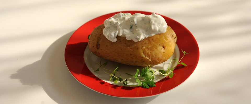 Kartoffel mit Quark auf einem Teller mit rotem Rand