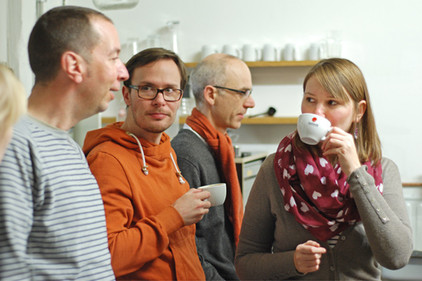 Teilnehmer des Kurses reden und trinken Kaffee